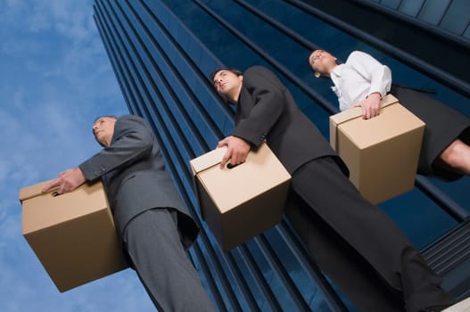 Low angle view of business executives carrying boxes