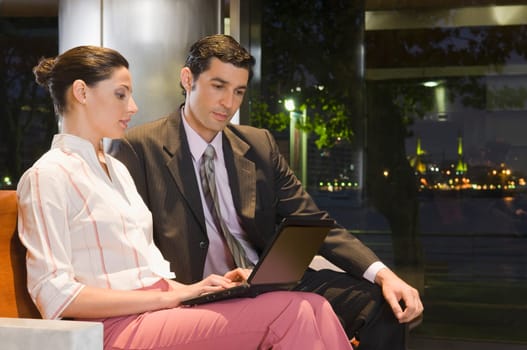 Business executives working on a laptop at an airport lounge