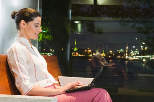 Businesswoman working on a laptop at an airport lounge
