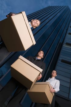 Low angle view of business executives carrying boxes