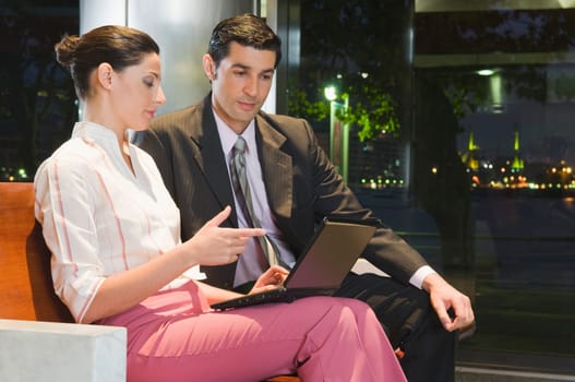 Business executives working on a laptop at an airport lounge