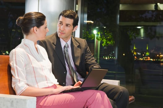 Business executives working on a laptop at an airport lounge