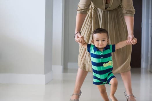 Mother helping her son in walking