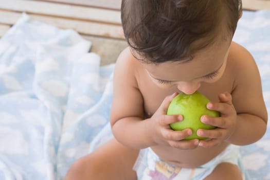 Baby boy eating an apple