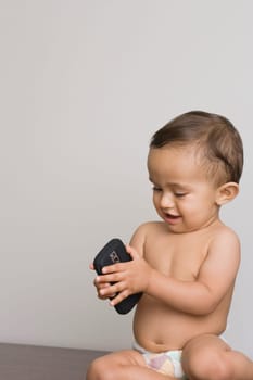 Baby boy playing with a mobile phone
