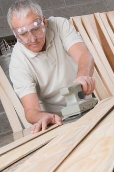 Carpenter planing a wooden plank