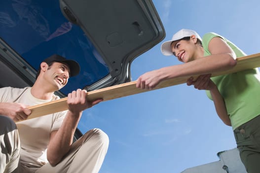 Couple pulling a wooden plank from each other