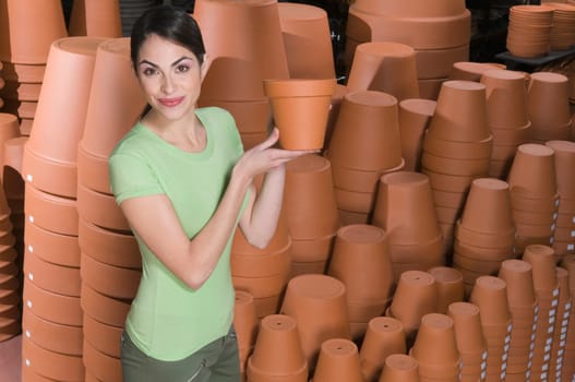 Portrait of a woman holding flower pot in a garden center