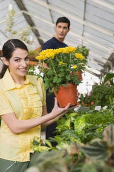 Couple choosing potted plants in a garden center