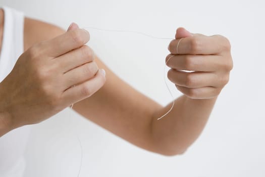 Close-up of a person's hand holding a dental floss