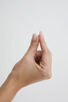 Close-up of a person's hand holding a pill