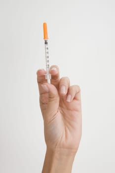 Close-up of a person's hand holding a syringe