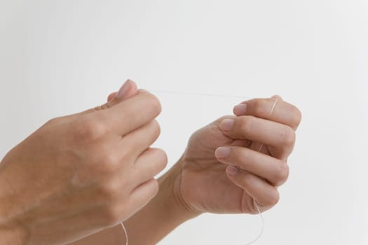 Close-up of a person's hand holding a dental floss
