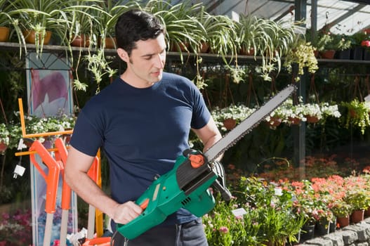 Man holding a chainsaw in a hardware store