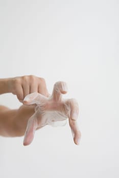 Close-up of a person's hands putting on a surgical glove