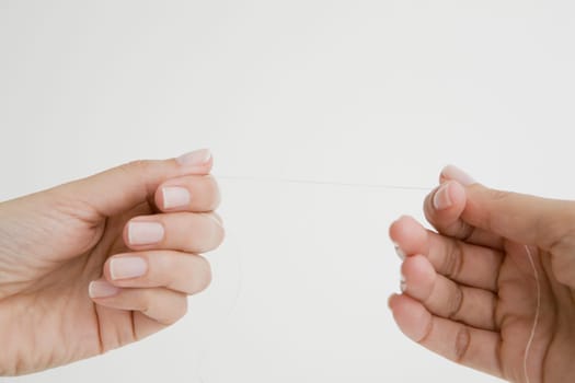 Close-up of a person's hand holding a dental floss