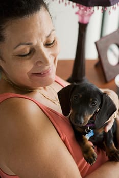 Senior woman holding small dog