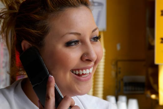 Close-up of a female ice-cream shop owner talking on a mobile phone