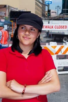 Close-up of a young woman standing with her arms crossed