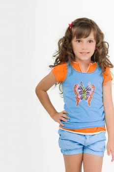 Portrait of a girl standing with her hand on her hip and smiling
