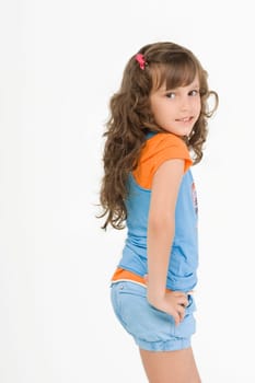 Side profile of a girl standing with her hand on her hip and smiling