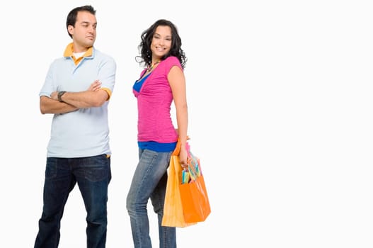 Young woman holding shopping bags with a young man standing beside her