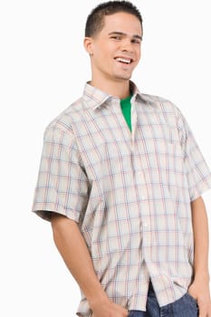 Portrait of a young man standing with his thumbs in his pockets and smiling