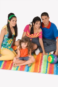 High angle view of four people sitting together on a rug