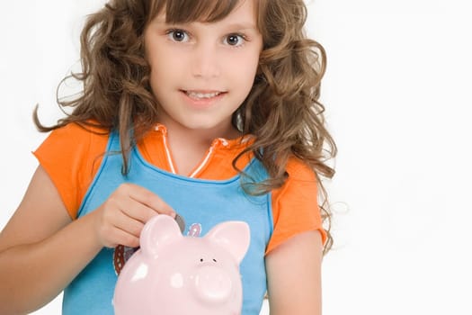 Portrait of a girl putting a coin into a piggy bank