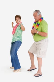 Senior man playing ukulele with a senior woman dancing in front of him