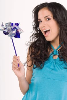 Portrait of a teenage girl holding a pinwheel and looking surprised