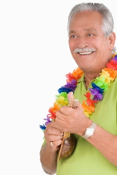 Close-up of a senior man playing ukulele and smiling