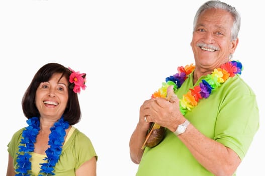 Senior man playing ukulele with a senior woman dancing beside him
