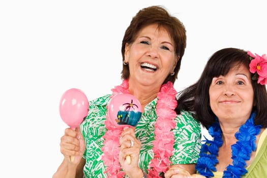 Portrait of a senior woman playing maracas and her friend grinning beside her