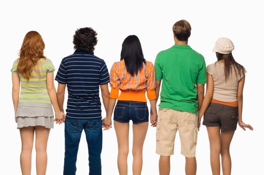 Rear view of three young women and two men standing with holding their hands