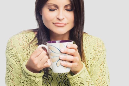 Close-up of a young woman holding a cup of coffee