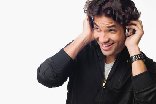 Close-up of a young man listening to music and smiling