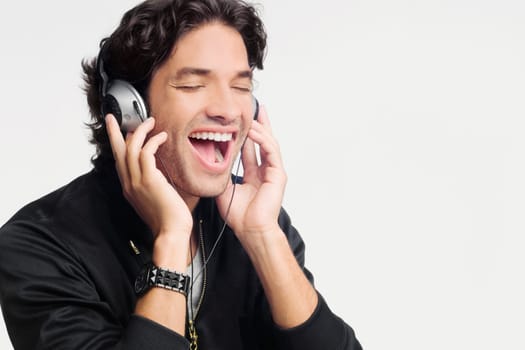 Close-up of a young man listening to music and laughing