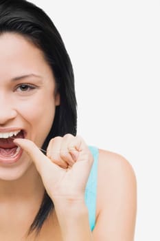 Portrait of a young woman flossing her teeth