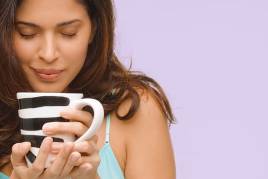 Close-up of a young woman holding a mug of coffee