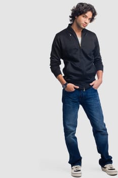 Portrait of a young man standing with his hands in his pockets