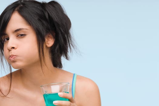 Portrait of a young woman gargling