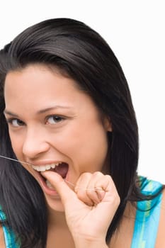Portrait of a young woman flossing her teeth