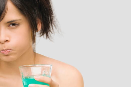 Portrait of a young woman gargling
