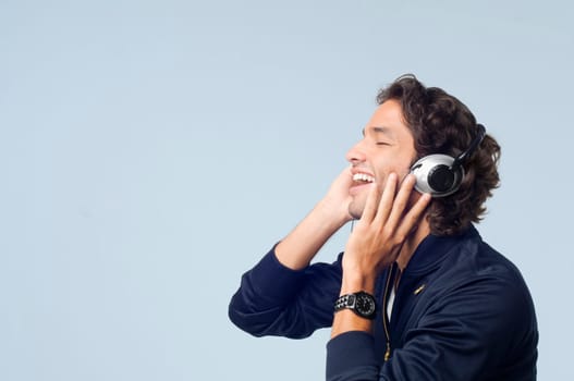 Side profile of a young man listening to music and smiling