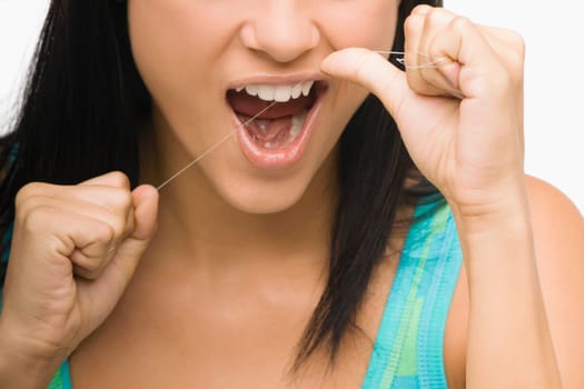 Close-up of a young woman flossing her teeth