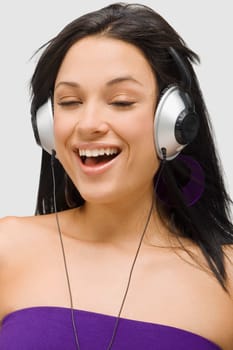 Close-up of a young woman wearing headphones and listening to music