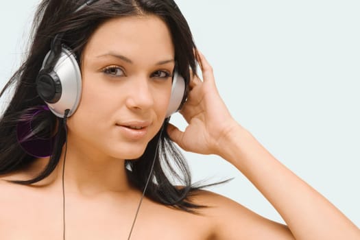 Portrait of a young woman wearing headphones and listening to music