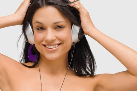 Portrait of a young woman wearing headphones and listening to music