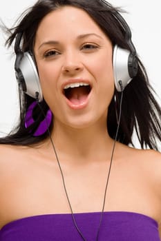 Close-up of a young woman wearing headphones and listening to music